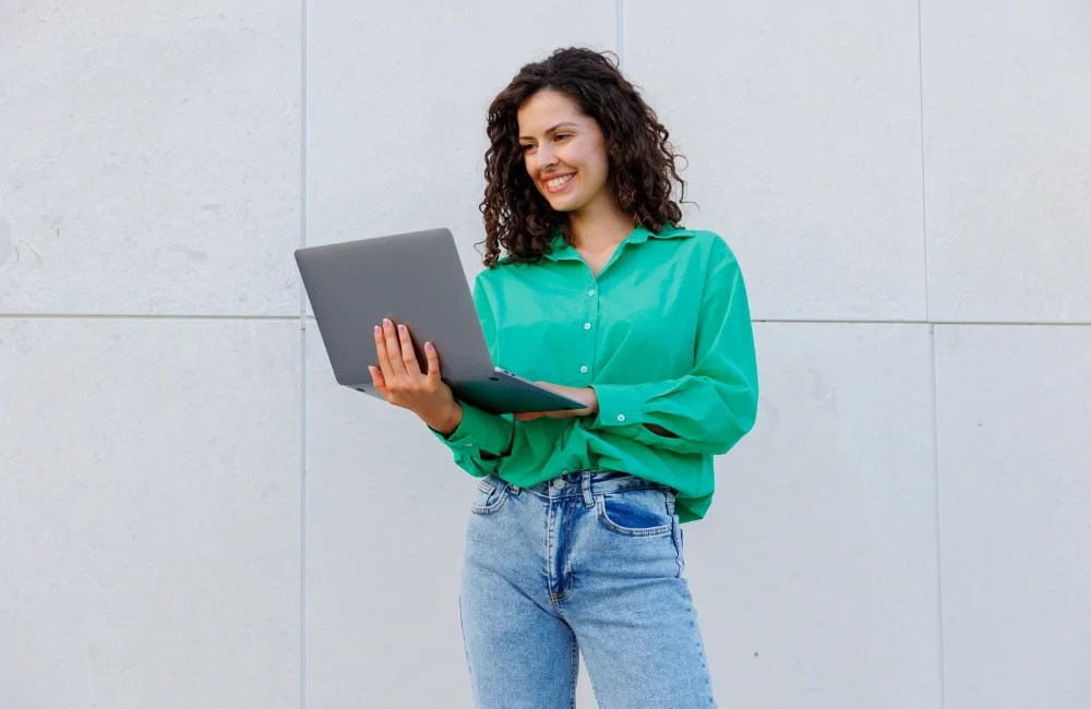 Woman smiling and holding laptop